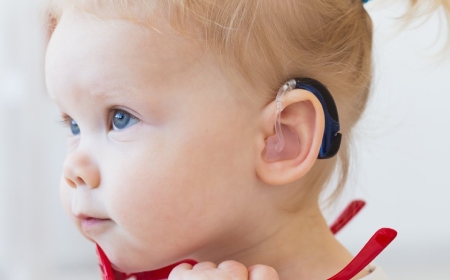 Baby girl wearing a hearing aid section mobile